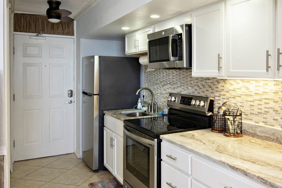 Renovated kitchen with full size stainless steel appliances.