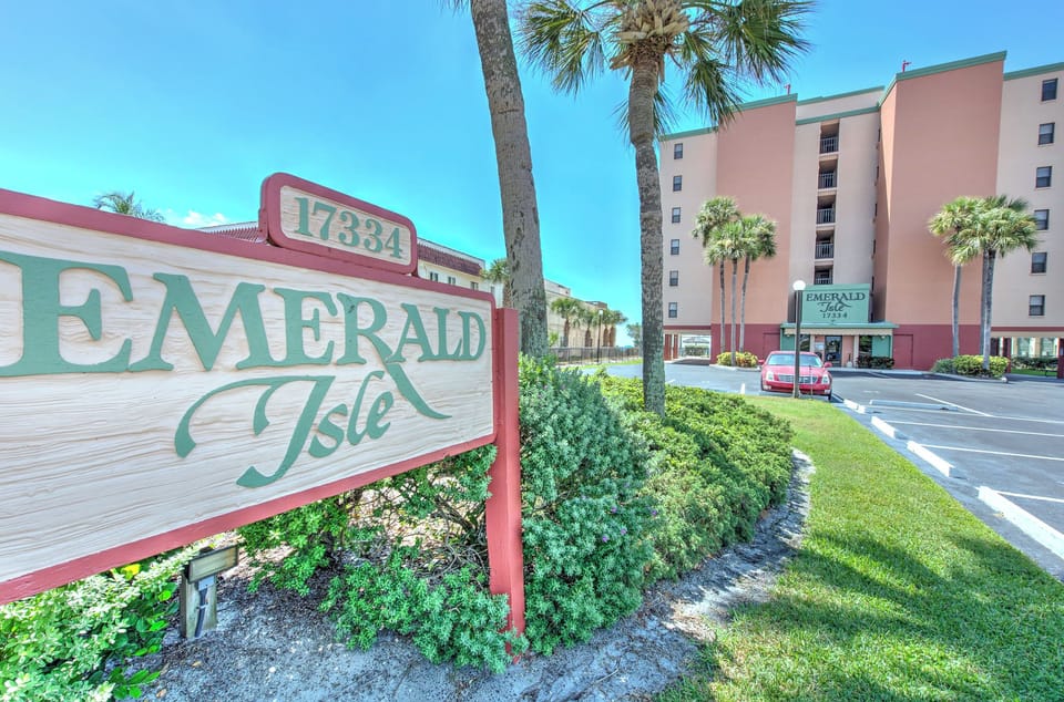 Emerald Isle property entrance welcomes guests with tropical landscaping and convenient parking.
