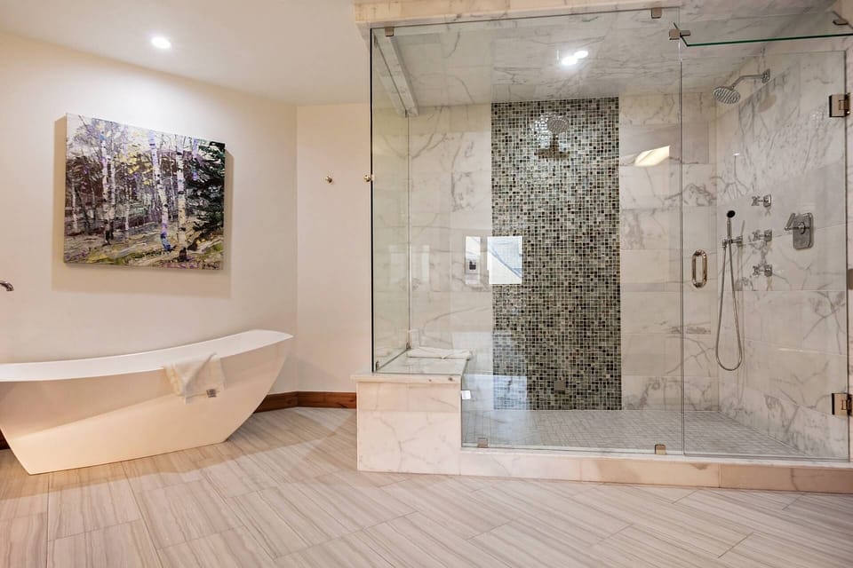 Oversized walk in steam shower with double rain shower heads.