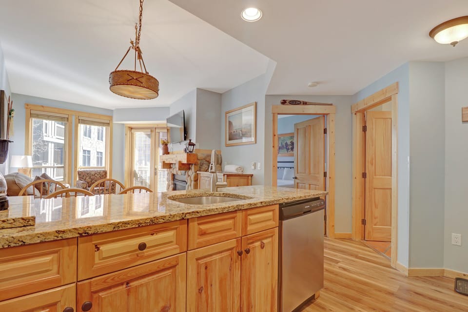 Step into your beautifully appointed kitchen where warm wood cabinetry and granite countertops invite you to prepare memorable meals. Natural light floods through large windows while you cook, creating a cozy heart of the home perfect for your mountain get