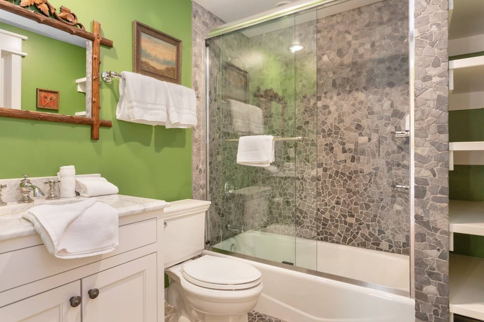This bathroom is shared with the twin bedroom and offers a stone-lined, combination tub & shower!