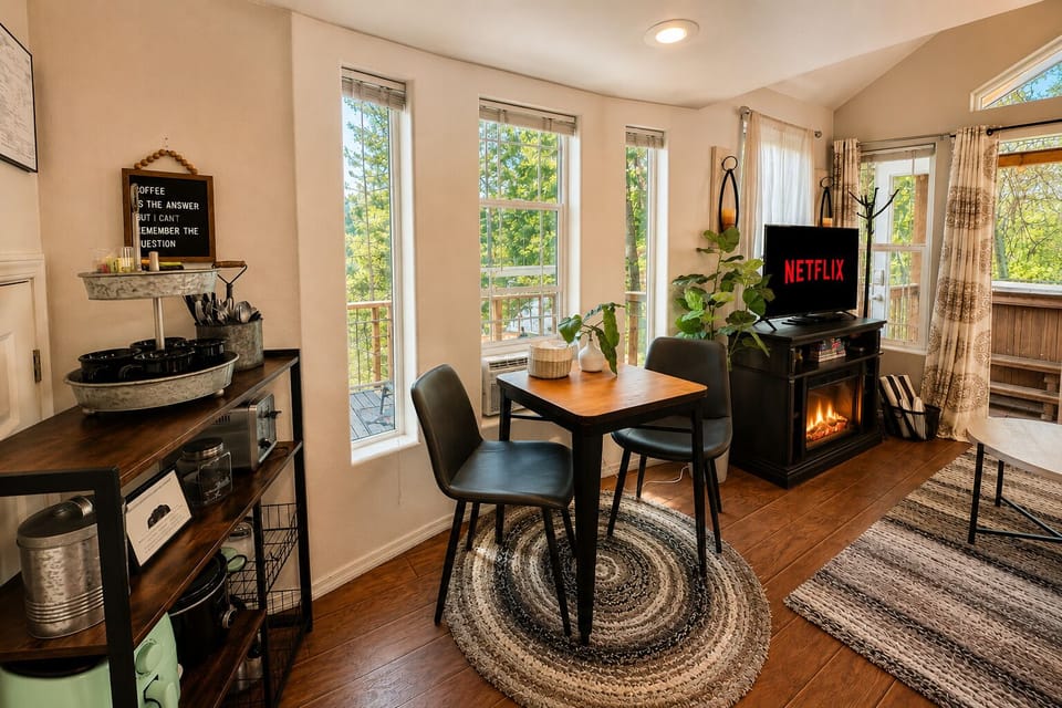 Small dining table with mountain and river views out the windows.