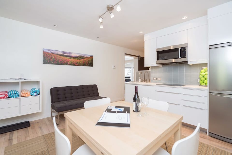 The kitchen has a small dining table for 4 people and a small loveseat sofa.