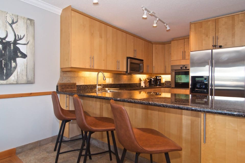 Another shot of the kitchen with full size appliances and family friendly breakfast bar