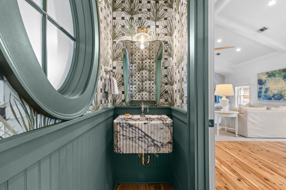 Powder room with a statement vessel sink and porthole window