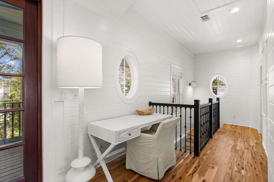 Built-in desk nook beside the iron stair railing