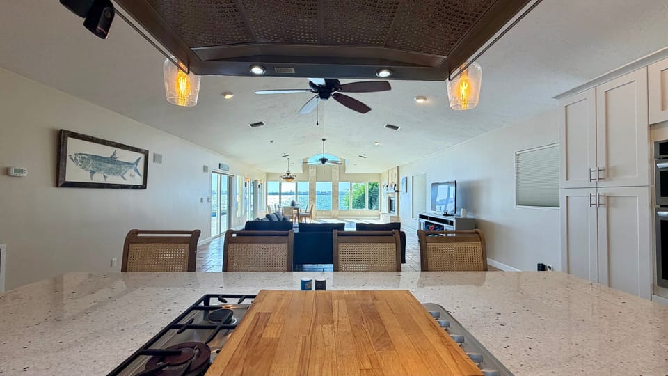 Kitchen island with additional prep and dining surface, open to the great room and dining area beyond