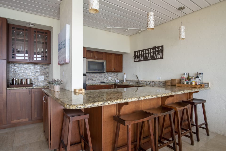 The beautifully renovated kitchen offers granite counters, stainless steel appliances, and extra barstool seating.