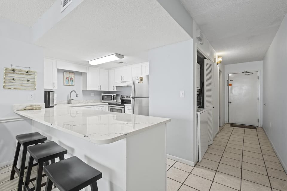Kitchen - The spacious kitchen features a large eat-in bar with seating.