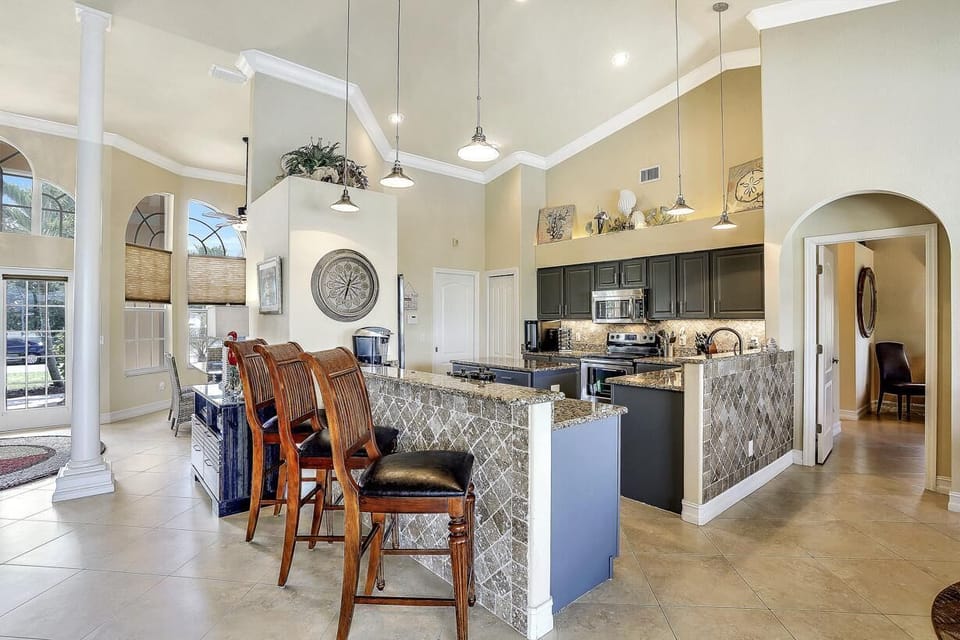 Granite-topped breakfast bar with seating and view over the open plan Kitchen and Living area