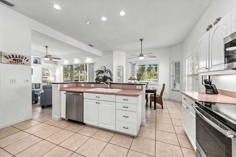 Morning light floods the open kitchen, where sleek surfaces and cozy dining spots set the stage for memorable meals.