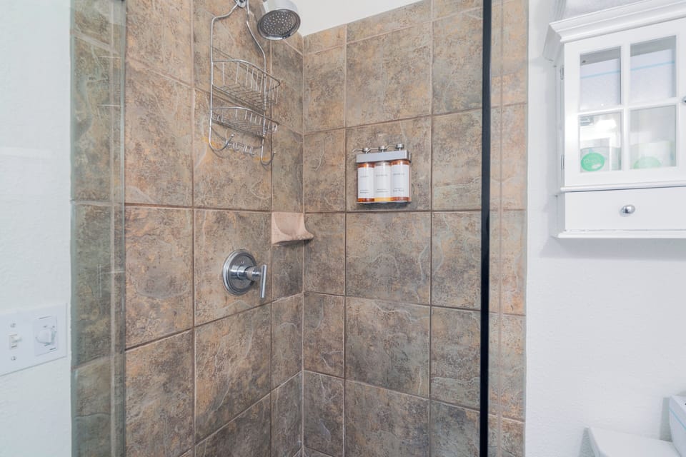 Step into your private tiled shower with rainfall showerhead, handy corner caddy, and built-in niche for your toiletries—everything you need for a refreshing start to your day.