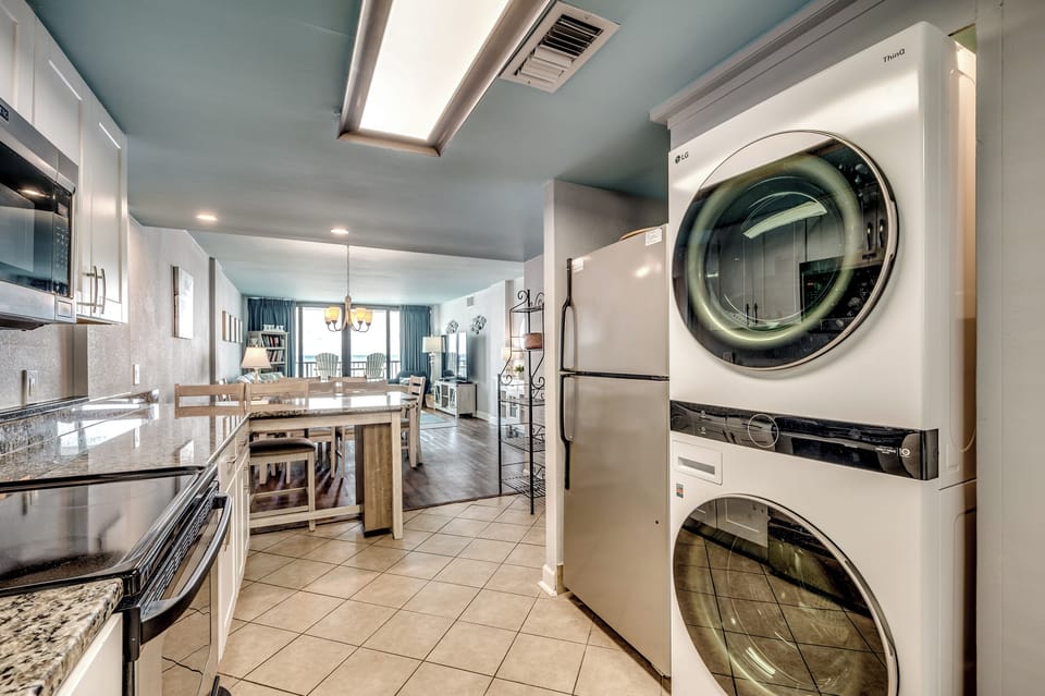 Kitchen has stainless appliances and a stackable washer/dryer