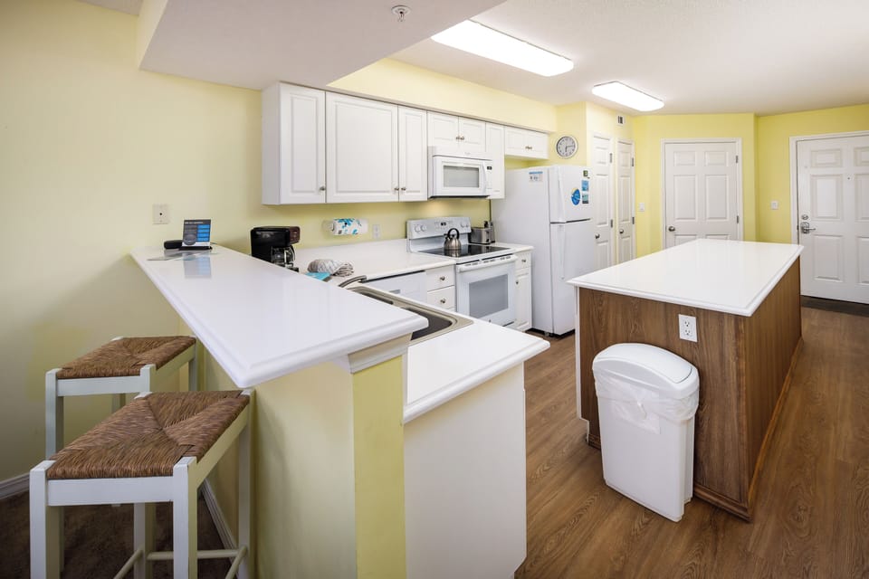 Kitchen - This bright, white kitchen has all the necessities including a microwave, coffee maker, and a blender.