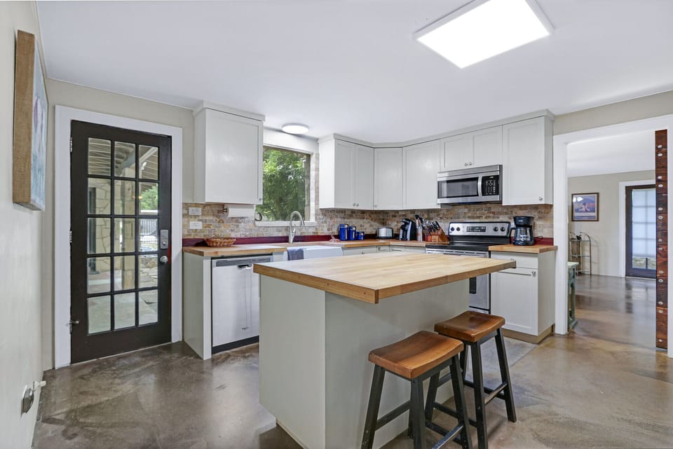 The kitchen features a large island with seating and stainless steel appliances
