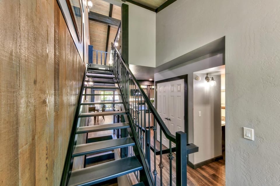 Step into your stylish entry where modern industrial design meets warm comfort, featuring sleek metal stairs and polished floors.