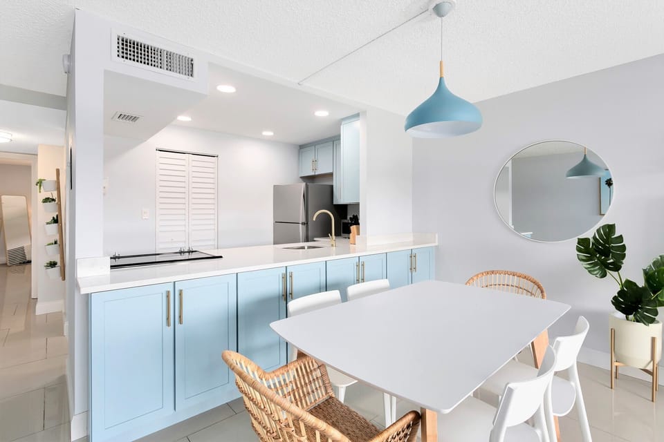 Modern dining area with a sleek design, soft lighting, and a seamless kitchen connection.