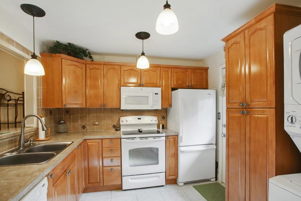 The kitchen features white appliances, a tile floor and a tiled backsplash.