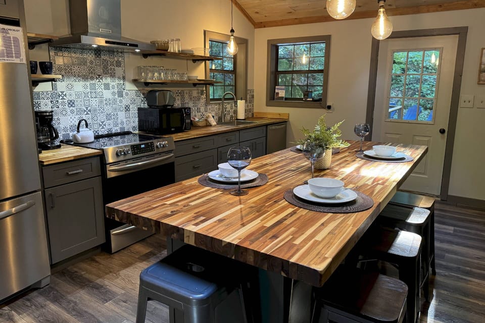 The large kitchen island seats all guests. All dishes, silverware, and cooking essentials are included for a night spent in.