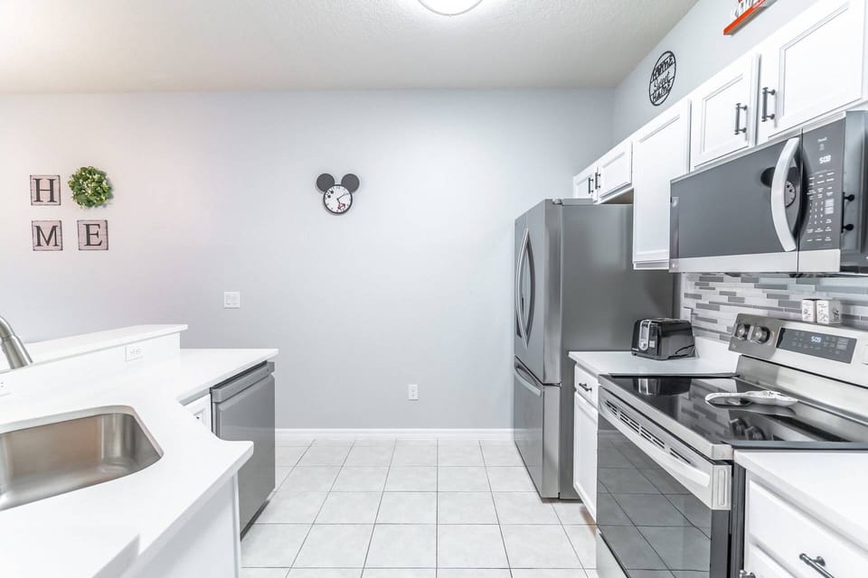 Bright kitchen with stainless steel appliances and tiled backsplash