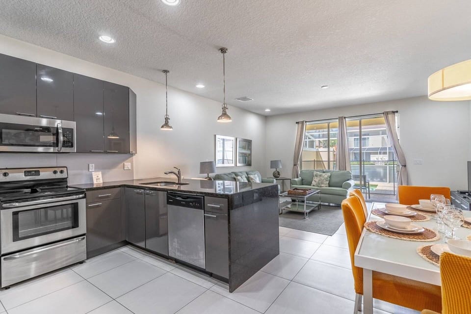 Modern kitchen with granite waterfall counters and stainless steel appliances