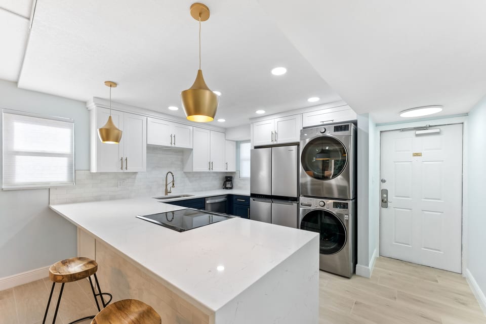 Contemporary kitchen with sleek countertops and breakfast bar that seats three
