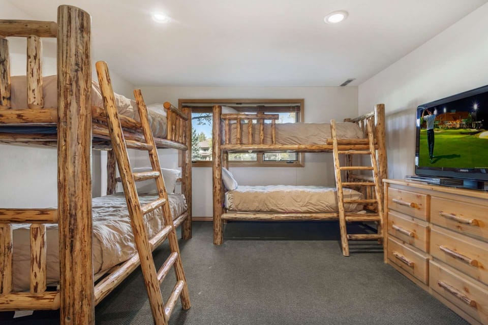 Bedroom 3 features two twin over twin bunk beds, large dresser and flat-screen tv.