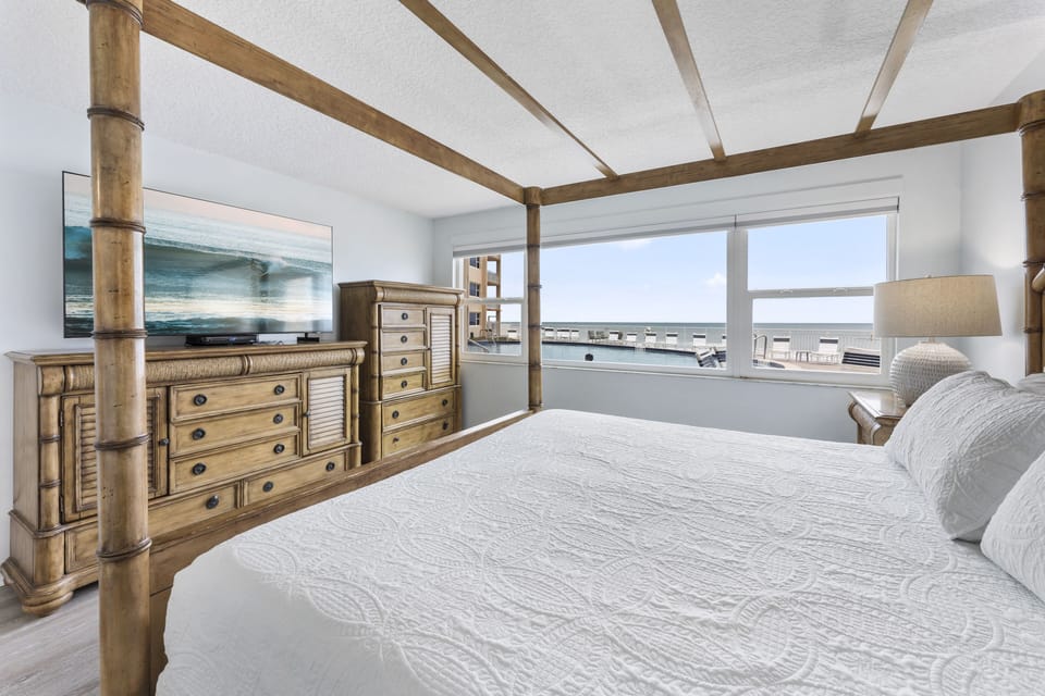Spacious bedroom with a luxurious four-poster bed and panoramic ocean views