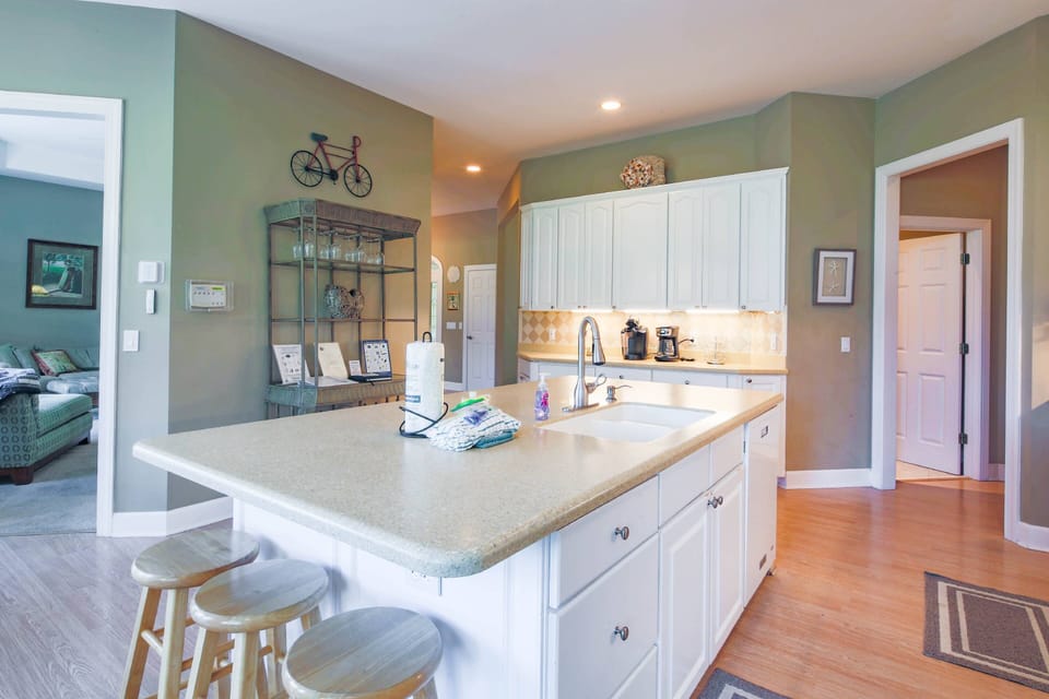 The kitchen features a central island, which cabinetry and a tiled backsplash.