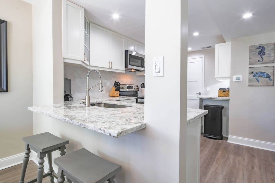 The kitchen features granite counters, white cabinets and stainless steel appliances.