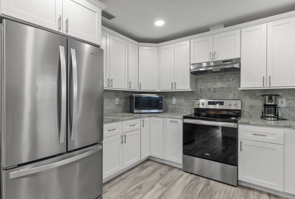 Modern kitchen with stainless steel appliances, granite countertops, and all the essentials for effortless vacation cooking.