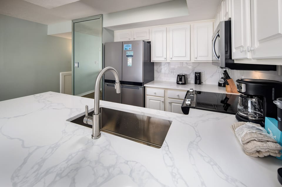 Kitchen - Featuring a quartz island and backsplash.