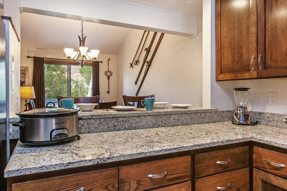 View from kitchen to dining and sliding glass doors leading to the deck that looks out to the 11th tee box.