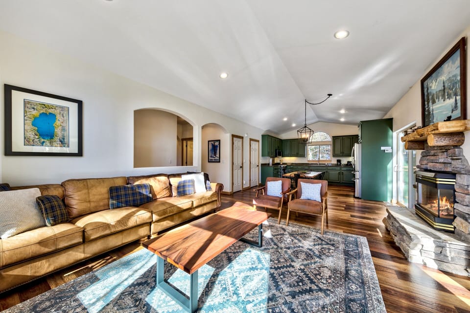 Sink into plush leather seating by your crackling stone fireplace, where rustic charm meets modern comfort in this inviting open-concept retreat.
