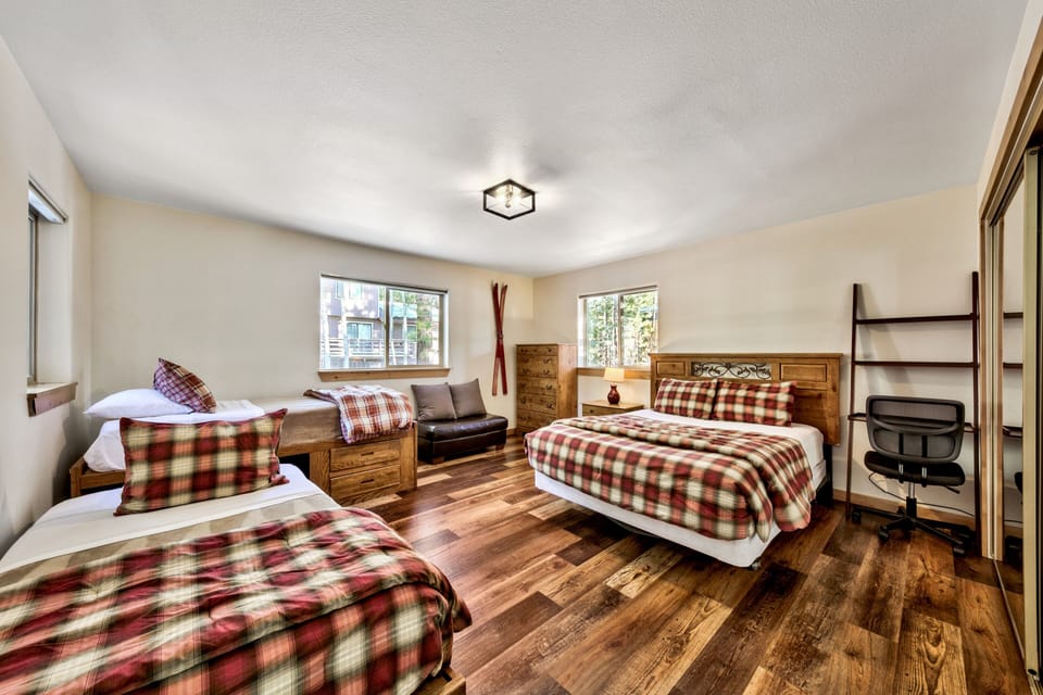 Settle into your cozy cabin-style room with rustic wood furnishings and warm plaid bedding that invites restful mountain nights.