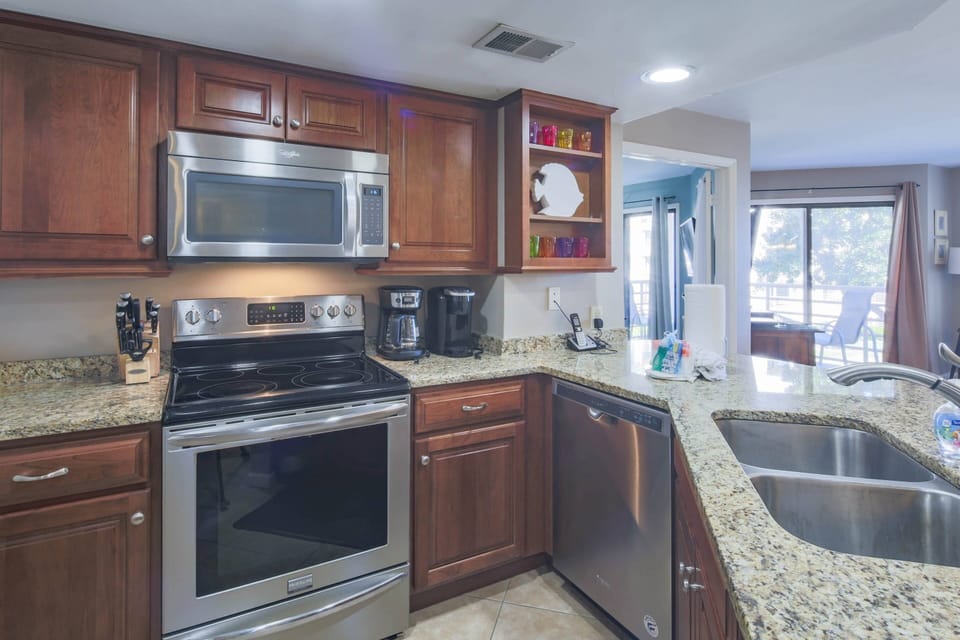 The kitchen features stainless steel appliances and granite countertops.