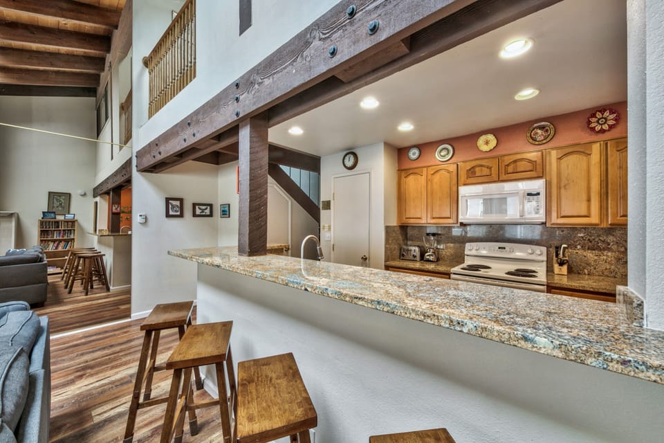 This spacious kitchen features granite counters and bar seating, perfect for cooking meals and gathering with loved ones.