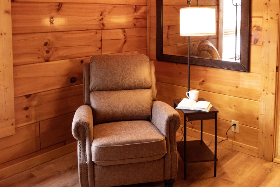 This main floor king suite offers an open floor plan with a designated reading space and attached newly renovated walk-in shower.