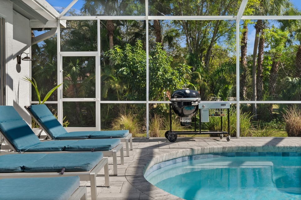 Poolside loungers and grill inside the screened lanai for all-day comfort