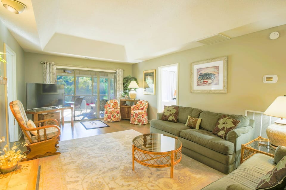 Relax & unwind in this comfortable living room with screened-in porch overlooking the inlet!