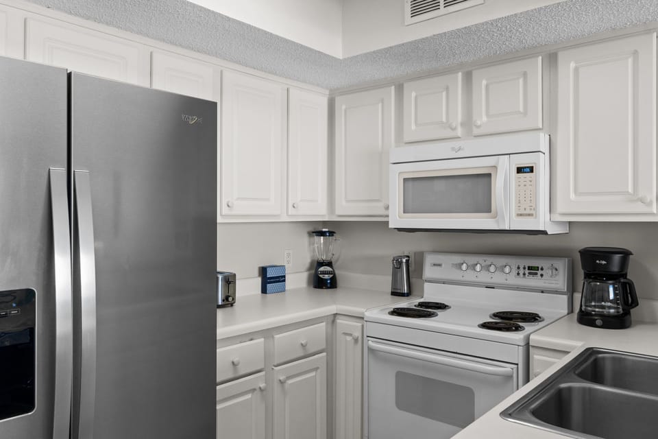 Kitchen - The kitchen has full-size appliances and is stocked with dishes and cooking supplies for all your vacation meal needs.