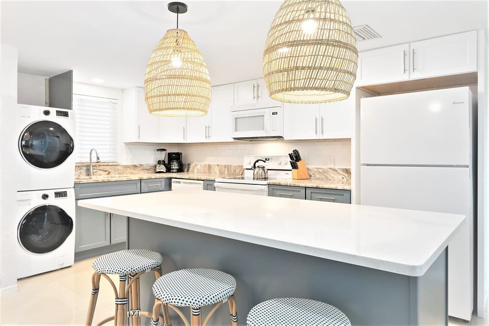Sophisticated kitchen with quartz and granite countertops, modern appliances, and a convenient washer & dryer.