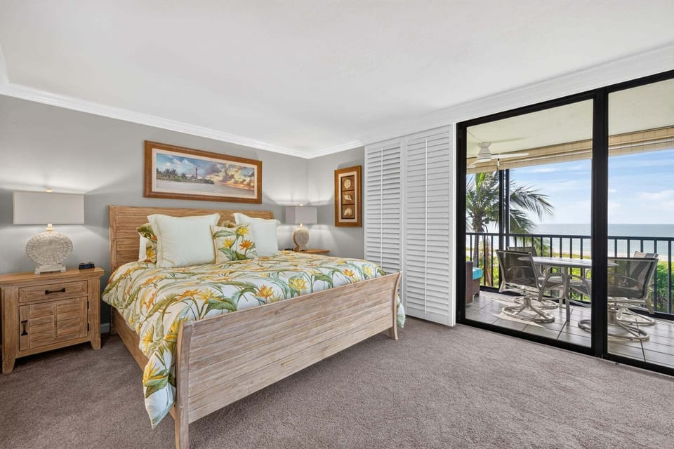 Primary bedroom with slider access to private screened lanai and gorgeous beachfront views