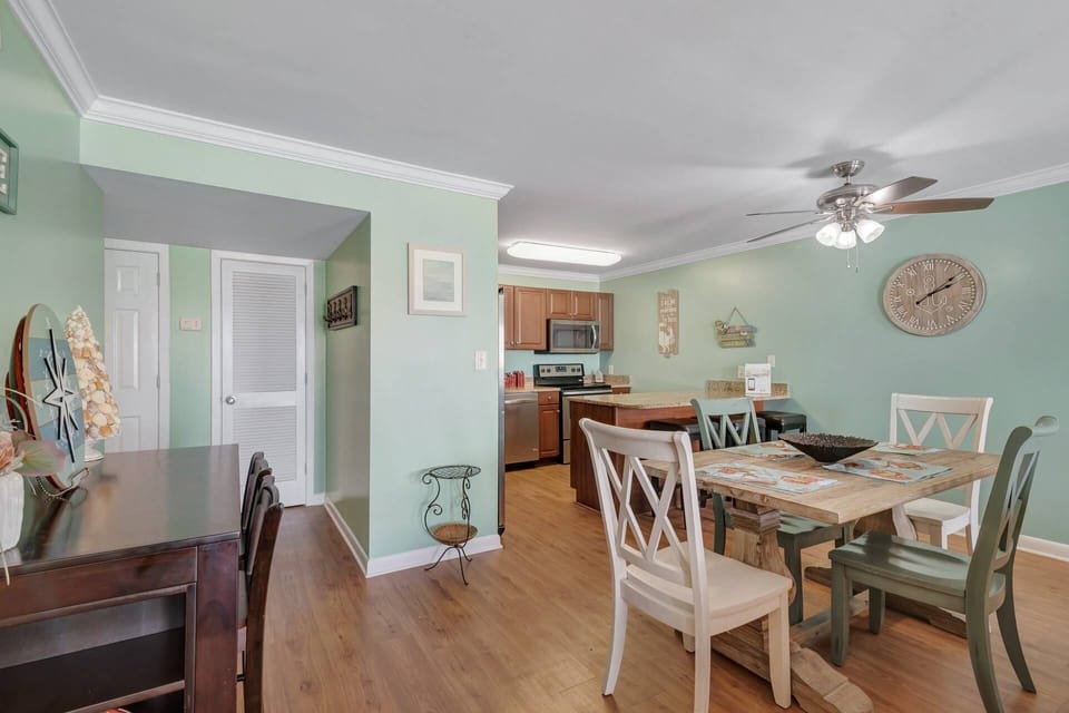 View of the dining area into the fully equipped kitchen. Dining for four at the table (2 chairs at the side table, as well), and three at the breakfas