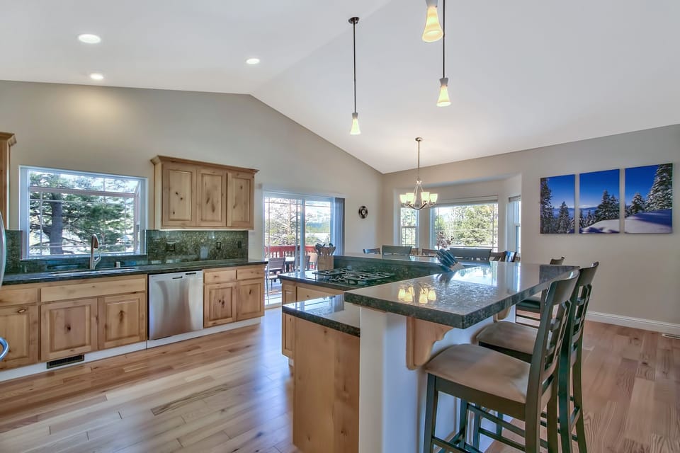 Your spacious kitchen features granite countertops, warm wood cabinetry, and a breakfast bar where you can enjoy morning coffee with garden views.