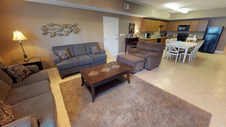 Living room with plenty of seating, and open concept to with the kitchen and dining area.