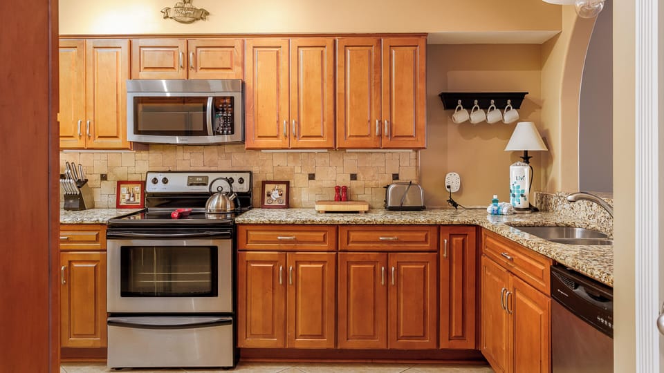 A fully equipped kitchen featuring essential appliances and a functional, streamlined layout.
