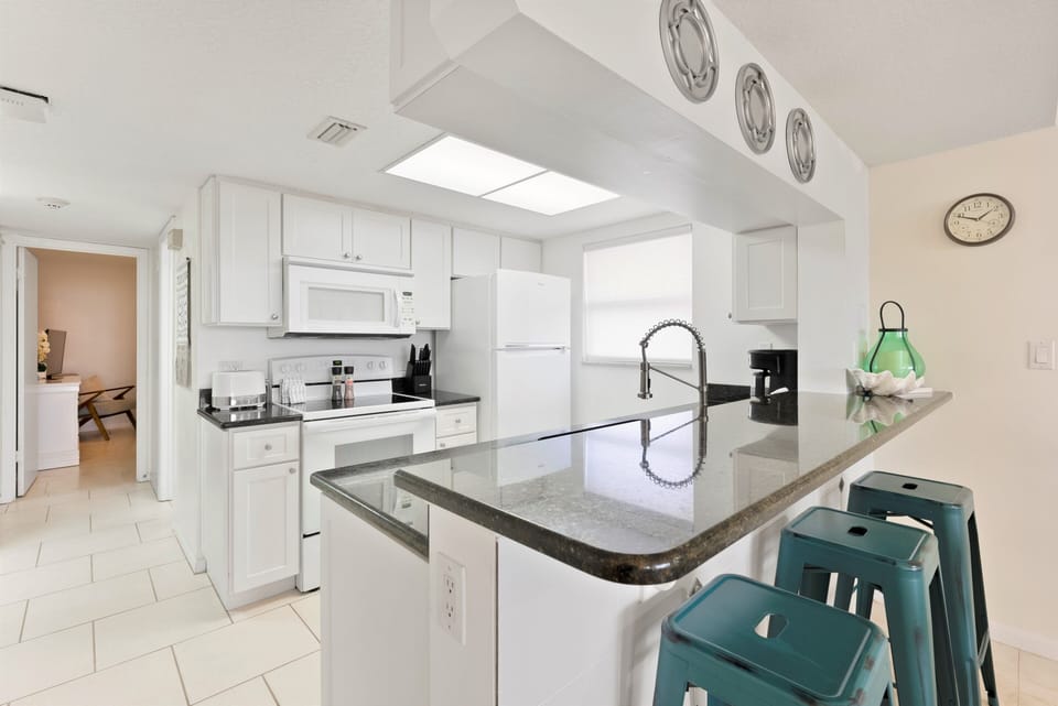 Contemporary kitchen with a large island, stylish barstools, and modern fixtures.