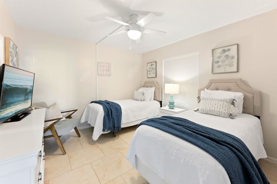 Guest bedroom with two twin beds, closet, TV