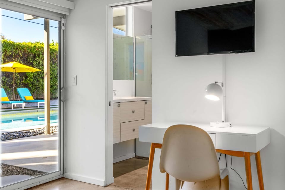 Your bright workspace overlooks the sparkling pool, perfect for catching up on emails before diving in for a refreshing swim.